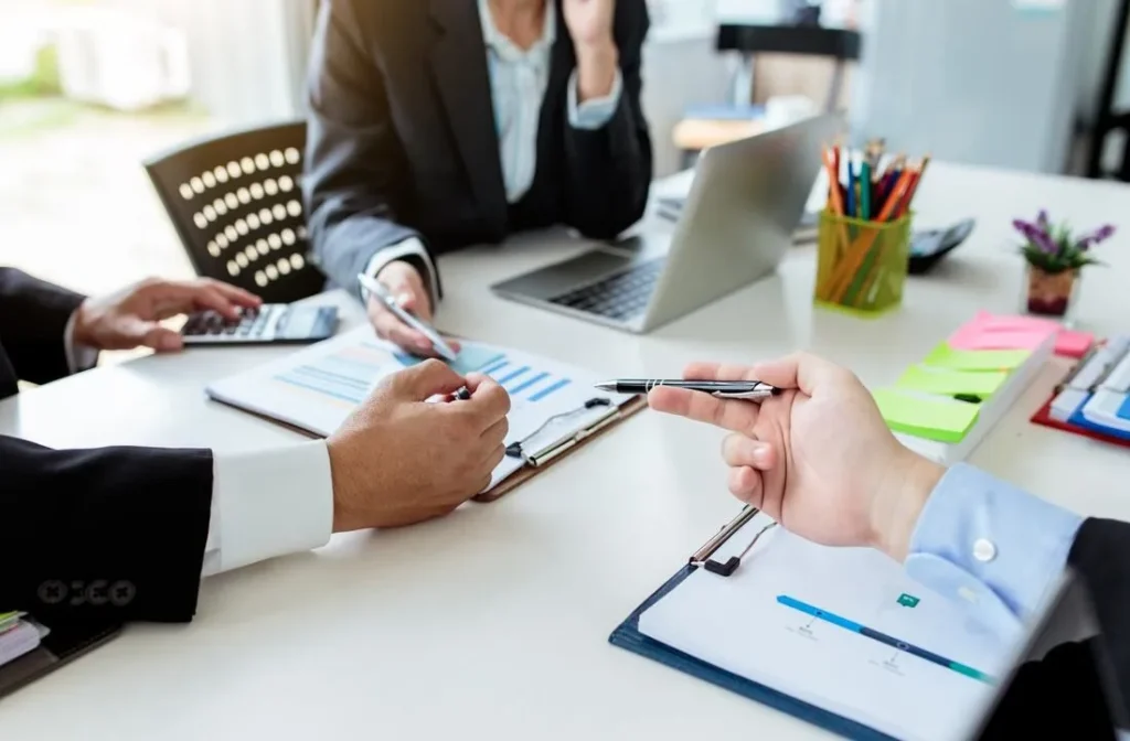 Business professionals reviewing financial charts and documents during an office meeting